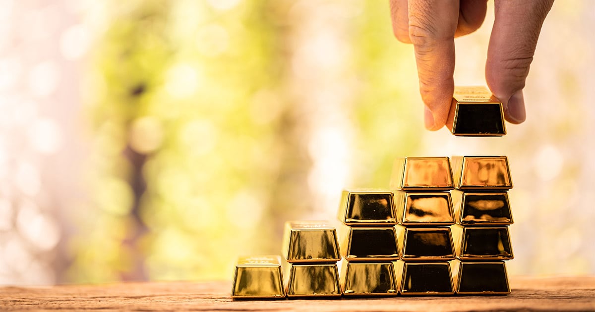 Gold Bars Being stacked to represent Investing in gold